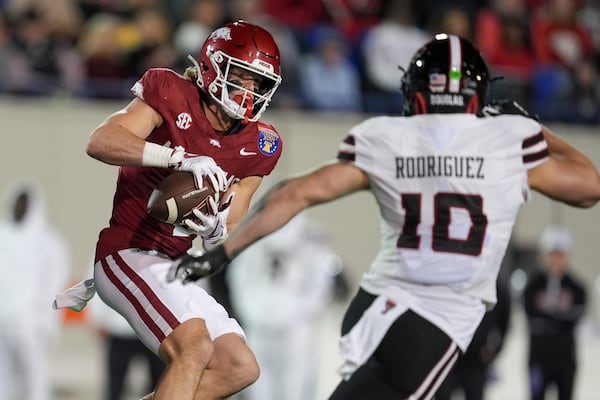 Arkansas wide receiver Isaac TeSlaa (4) makes a catch past Texas Tech linebacker Jacob Rodriguez (10) during the first half of the Liberty Bowl NCAA college football game Friday, Dec. 27, 2024, in Memphis, Tenn. (AP Photo/George Walker IV)