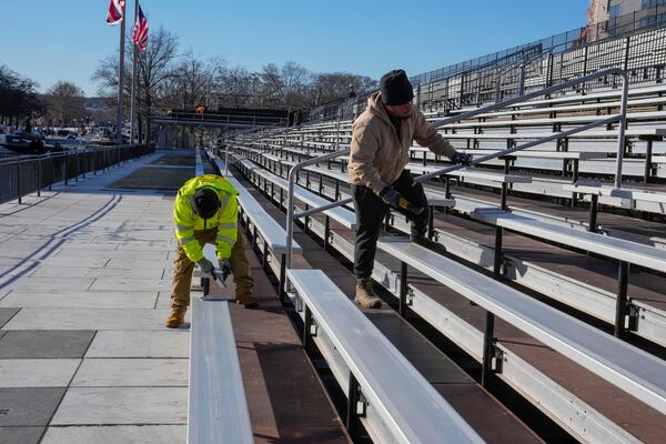 FILE - mWorkers continue construction on bleachers at Freedom Plaza along Pennsylvania Avenue for parade seating ahead of the upcoming inauguration of President-elect Donald Trump in Washington, Jan. 14, 2025. (AP Photo/Jon Elswick, File)