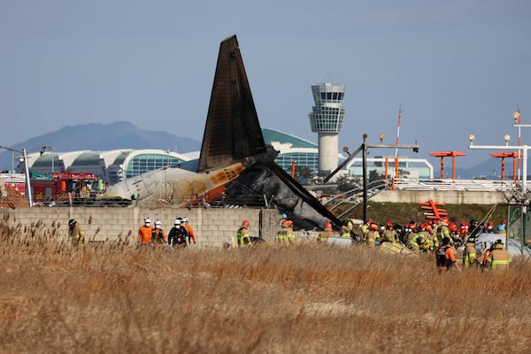 Firefighters and rescue team members work at Muan International Airport in Muan, South Korea, Sunday, Dec. 29, 2024. (Cho Nam-soo/Yonhap via AP)