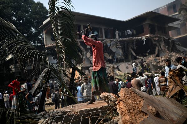 A man hammers the debris around the vandalized residence of Sheikh Mujibur Rahman, Bangladesh's former leader and the father of the country's ousted Prime Minister Sheikh Hasina, in Dhaka in Dhaka, Bangladesh, Thursday, Feb. 6, 2025. (AP Photo/Mahmud Hossain Opu)