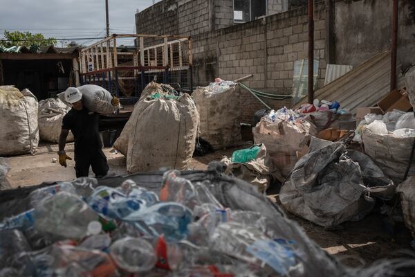 Jesus Cuevas, a Petgas technician, carries a bag filled with shredded plastic, at a recycling center in Boca del Rio, Veracruz, Mexico, Jan. 4, 2025. (AP Photo/Felix Marquez)