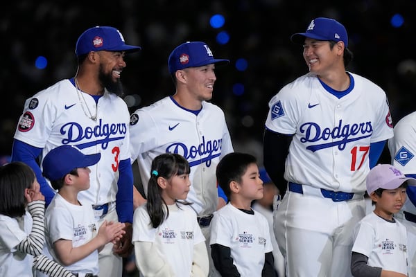 Los Angeles Dodgers' Teoscar Hernandez, left, Tommy Edman, center, and Shohei Ohtani (17) talk as they stand on the field during team introductions before an MLB Tokyo Series baseball game against the Chicago Cubs in Tokyo, Japan, Wednesday, March 19, 2025. (AP Photo/Eugene Hoshiko)