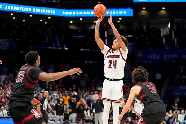 Louisville guard Chucky Hepburn scores the game winning basket between Stanford forward Chisom Okpara and guard Benny Gealer during the second half of an NCAA college basketball game in the quarterfinals of the Atlantic Coast Conference tournament, Thursday, March 13, 2025, in Charlotte, N.C. (AP Photo/Chris Carlson)