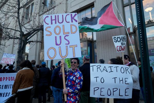 Demonstrators gather in front of the Central Library branch of the Enoch Pratt Free Library in Baltimore after Senate Democratic Leader Chuck Schumer's scheduled book tour event was postponed, Monday, March 17, 2025. (AP Photo/Stephanie Scarbrough)