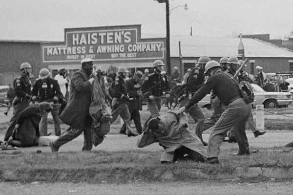 FILE - An Alabama state trooper swings a club at John Lewis, right foreground, chairman of the Student Nonviolent Coordinating Committee, to break up a civil rights voting march in Selma, Ala., March 7, 1965. (AP Photo, File)