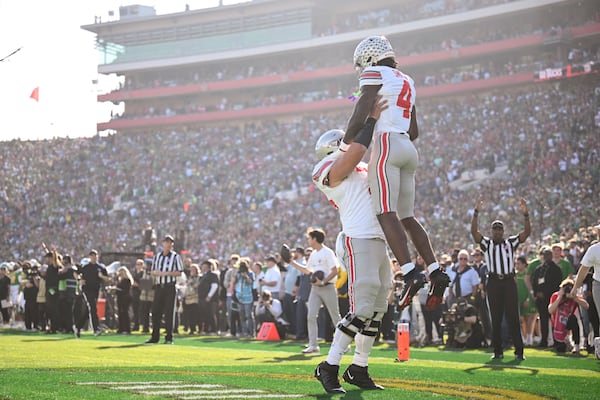 Ohio State offensive lineman Carson Hinzman (75) lifts wide receiver Jeremiah Smith (4) as they celebrate his touchdown during the first half in the quarterfinals of the Rose Bowl College Football Playoff against Oregon, Wednesday, Jan. 1, 2025, in Pasadena, Calif. (AP Photo/Kyusung Gong)