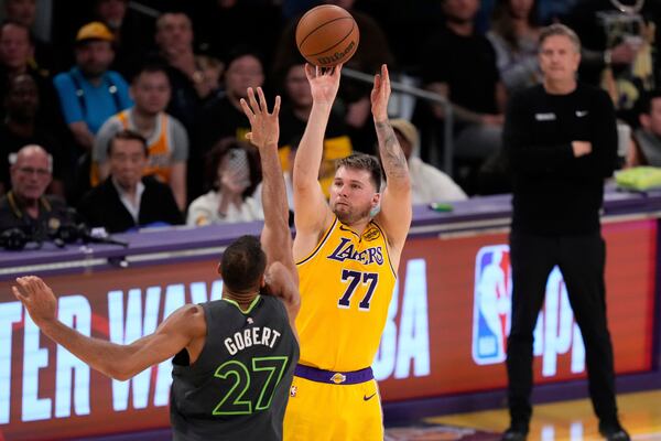 Los Angeles Lakers guard Luka Doncic, right shoots as Minnesota Timberwolves center Rudy Gobert defends during the second half in Game 5 of an NBA basketball first-round playoff series Wednesday, April 30, 2025, in Los Angeles. (AP Photo/Mark J. Terrill)