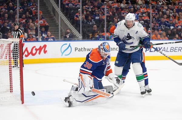 Vancouver Canucks' J.T. Miller (9) is stopped by Edmonton Oilers goalie Calvin Pickard (30) during first-period NHL hockey game action in Edmonton, Alberta, Thursday, Jan. 23, 2025. (Jason Franson/The Canadian Press via AP)