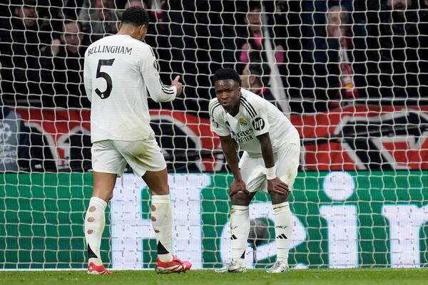 Real Madrid's Vinicius Junior, right, reacts after missing a penalty kick during the Champions League round of 16, second leg, soccer match between Atletico Madrid and Real Madrid at the Metropolitano stadium in Madrid, Spain, Wednesday, March 12, 2025. (AP Photo/Bernat Armangue)