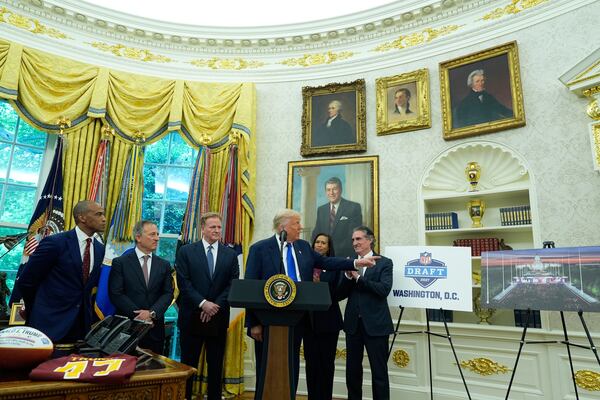 Interior Secretary Doug Burgum, from right, District of Columbia Mayor Muriel Bowser, and from left, Secretary of Housing and Urban Development Scott Turner, Washington Commanders owner Josh Harris and NFL Commissioner Roger Goodell listen as President Donald Trump speaks during an event to announce that the 2027 NFL Draft will be held on the National Mall, in the Oval Office of the White House, Monday, May 5, 2025, in Washington. (AP Photo/Alex Brandon)