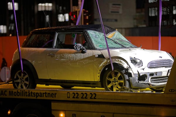 A car is lifted onto a tow truck at the scene where a driver drove a car into a labor union demonstration in Munich, Germany, Thursday Feb. 13, 2025. (Tizian Gerbing/dpa via AP)