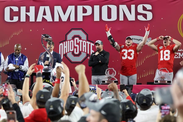 Ohio State head coach Ryan Day, middle right, defensive end Jack Sawyer (33) and quarterback Will Howard (18) celebrate after the Cotton Bowl College Football Playoff semifinal game against Texas, Friday, Jan. 10, 2025, in Arlington, Texas. (AP Photo/Gareth Patterson)