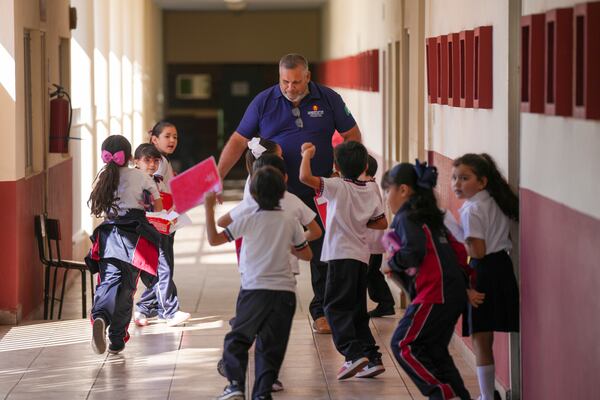 Students welcome retired municipal police officer Elias Sanchez prior to a workshop about security at a public school in Culiacan, Sinaloa state, Mexico, Tuesday, Feb. 25, 2025. (AP Photo/Fernando Llano)