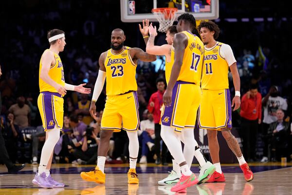 Los Angeles Lakers guard Luka Doncic, center, is congratulated after scoring by forward LeBron James, second from left, guard Austin Reaves, left, forward Dorian Finney-Smith, forward Dorian Finney-Smith, second from right, and center Jaxson Hayes during the second half of an NBA basketball game against the Minnesota Timberwolves, Thursday, Feb. 27, 2025, in Los Angeles. (AP Photo/Mark J. Terrill)