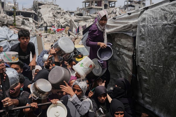 Palestinians struggle to get donated food at a community kitchen in Jabalia, northern Gaza Strip, Thursday, May 15, 2025. (AP Photo/Jehad Alshrafi)