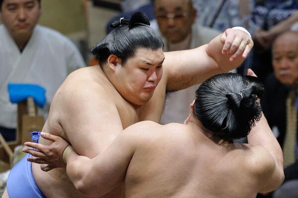 Onosato, left, wrestles with Wakamotoharu in a sumo wrestling tournament at Ryogoku Kokugikan arena in Tokyo, Sunday, May 11, 2025. (Taichi Nagahisa/Kyodo News via AP)