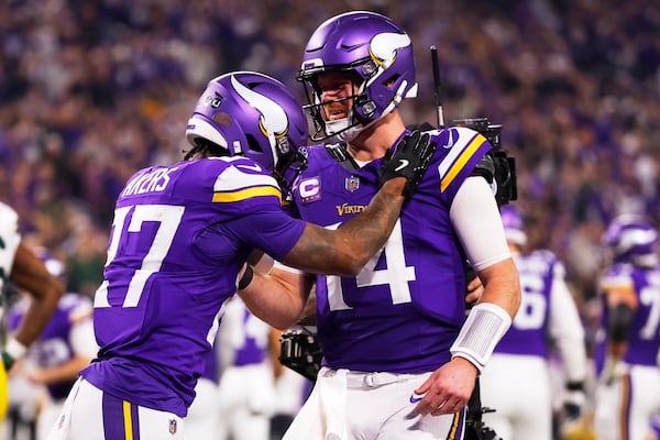 Minnesota Vikings' Sam Darnold congratulates Cam Akers on a touchdown catch during the second half of an NFL football game against the Green Bay Packers Sunday, Dec. 29, 2024, in Minneapolis. (AP Photo/Bruce Kluckhohn)