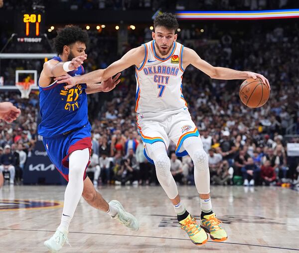 Oklahoma City Thunder forward Chet Holmgren, right, drives past Denver Nuggets guard Jamal Murray in overtime of Game 3 in the Western Conference semifinals of the NBA basketball playoffs, Friday, May 9, 2025, in Denver. (AP Photo/David Zalubowski)