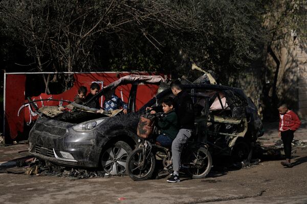 Palestinian kids look at the wreckage of a vehicle destroyed in an Israeli strike that killed two Islamic Jihad militants in the West Bank village of Kabatiya, Sunday, Feb. 2, 2025. (AP Photo/Majdi Mohammed)