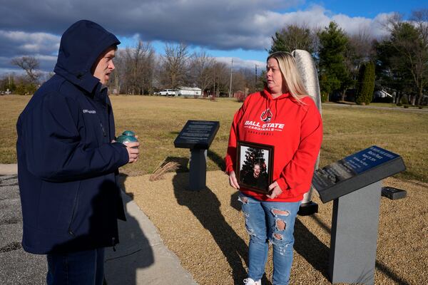 Eric Pranger and Shannon Doughty talk by a memorial, Saturday, Dec. 21, 2024, in Westfield, Ind. (AP Photo/Darron Cummings)