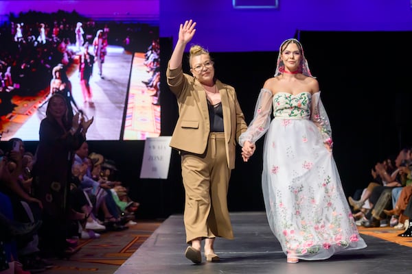 Designer Tishna Marlowe, left, is accompanied by a model wearing one of her designs during the 2025 Native Fashion Show, Friday, May 9, 2025, in Santa Fe, N.M. (AP Photo/Roberto E. Rosales)