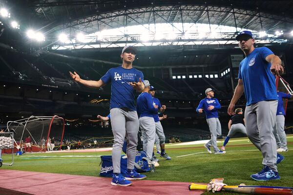 Los Angeles Dodgers' Hyeseong Kim, left, of South Korea, warms up with Dodgers' Austin Barnes, right, prior to a baseball game against the Arizona Diamondbacks Thursday, May 8, 2025, in Phoenix. (AP Photo/Ross D. Franklin)