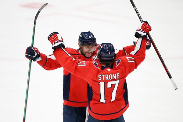 Washington Capitals left wing Alex Ovechkin (8) celebrates his empty net goal for a hat trick with center Dylan Strome (17) during the third period of an NHL hockey game against the Edmonton Oilers, Sunday, Feb. 23, 2025, in Washington. (AP Photo/Nick Wass)