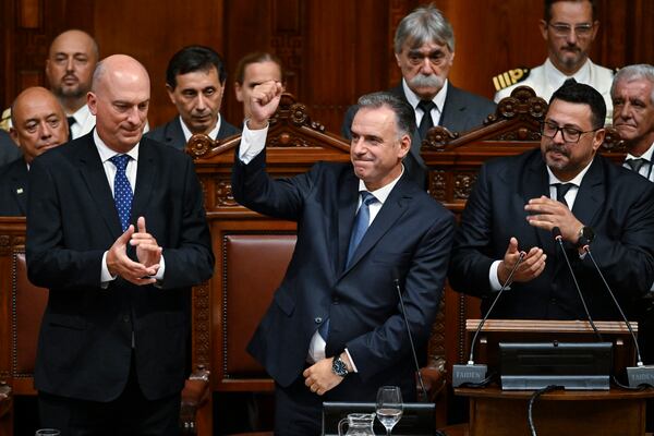 Uruguay's new President Yamandu Orsi raises his right fist during his swearing-in ceremony in Congress, on Inauguration Day in Montevideo, Uruguay, Saturday, March 1, 2025. (AP Photo/Santiago Mazzarovich)