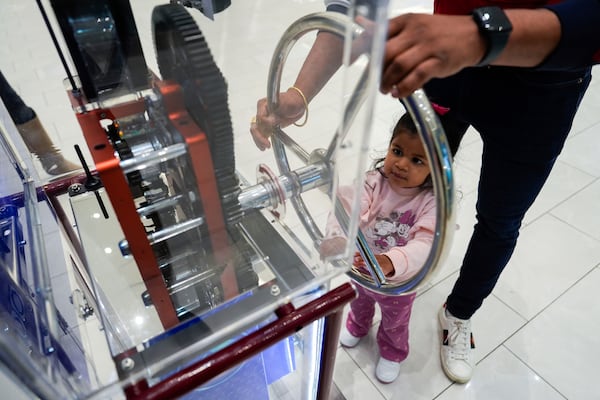 A girl uses a penny press machine at the American Dream mall, Sunday, March 2, 2025, in East Rutherford, N.J. (AP Photo/Julia Demaree Nikhinson)