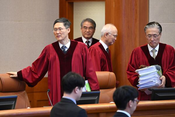 Judge Moon Hyung-bae, left, acting chief justice of South Korea's Constitutional Court, and other justices arrive at the courtroom for the final hearing over South Korea's impeached President Yoon Suk Yeol's imposition of martial law, at the Constitutional Court in Seoul, South Korea, Tuesday, Feb. 25, 2025. (Jung Yeon-je/Pool Photo via AP)