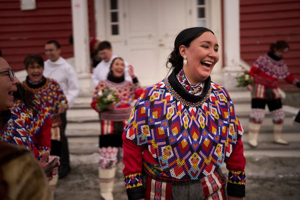 Malu Schmidt laughs next to her friends after getting married at the church of our Savior in Nuuk, Greenland, Saturday, Feb. 15, 2025. (AP Photo/Emilio Morenatti)