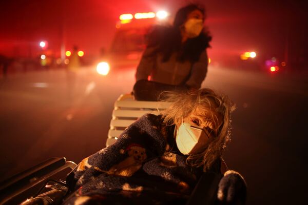 FILE - A resident of a senior center is evacuated as the Eaton Fire approaches Tuesday, Jan. 7, 2025 in Altadena, Calif. (AP Photo/Ethan Swope, File)