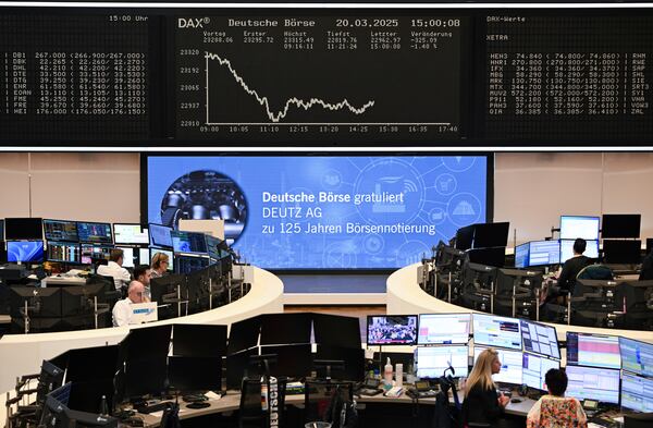 Stock market traders work behind their desks on the trading floor of the Frankfurt Stock Exchange, Germany, Thursday, March 20, 2025. (Arne Dedert/dpa/dpa via AP)