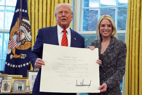 President Donald Trump presents Attorney General Pam Bondi with a document, after she was sworn in by Supreme Court Associate Justice Clarence Thomas, in the Oval Office of the White House, Wednesday, Feb. 5, 2025, in Washington. (AP Photo/Evan Vucci)