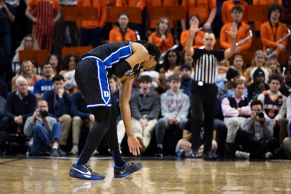 Duke forward Maliq Brown holds his dislocated shoulder during the first half of an NCAA college basketball game against Virginia, Monday, Feb. 17, 2025, in Charlottesville, Va. (AP Photo/Mike Kropf)