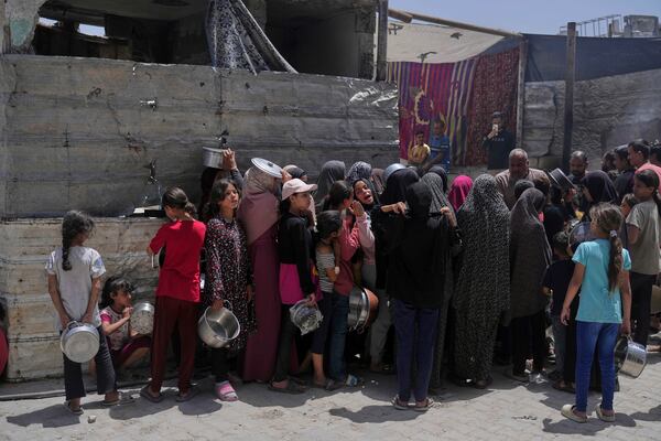 Palestinians line up for donated food at a community kitchen in Jabalia, in the northern Gaza Strip, on Monday, May 19, 2025. (AP Photo/Jehad Alshrafi)
