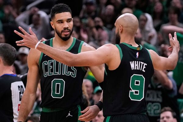 Boston Celtics forward Jayson Tatum (0) celebrates with teammate Derrick White while leading the Orlando Magic during the second half in Game 5 of a first-round NBA playoff basketball series, Tuesday, April 29, 2025, in Boston. (AP Photo/Charles Krupa)