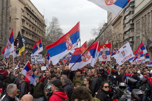 Protesters block a street while waving Serbian flags during a major anti-corruption rally led by university students in Belgrade, Serbia, Saturday, March 15, 2025. (AP Photo/Marko Drobnjakovic)