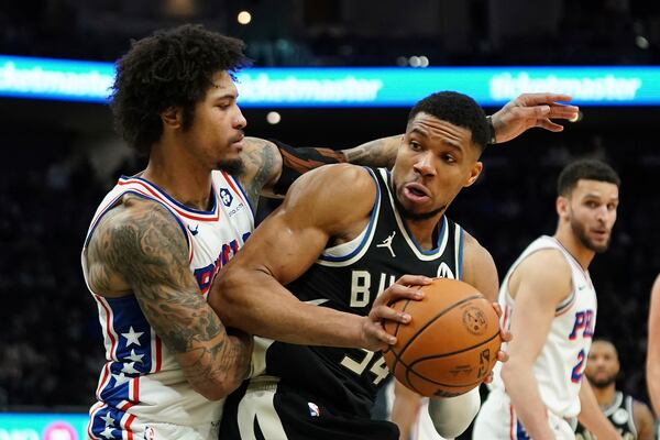 Milwaukee Bucks' Giannis Antetokounmpo, front right, drives to the basket against Philadelphia 76ers' Kelly Oubre Jr., left, during the second half of an NBA basketball game Sunday, Jan. 19, 2025, in Milwaukee. (AP Photo/Aaron Gash)