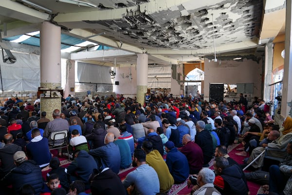 Palestinians take part in Friday prayers in the ruins of a Mosque that was partially destroyed by Israeli bombardment, in Nuseirat, Gaza Strip, Friday, March 14, 2025, during the holy Muslim month of Ramadan. (AP Photo/Abdel Kareem Hana)