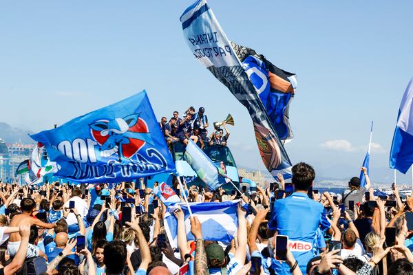 The crowd cheers as Napoli players celebrate winning their fourth Serie A soccer league title in an open-air bus parade alongside Naples' seafront, Italy, Monday, May 26, 2025. (Antonio Balasco/LaPresse via AP)