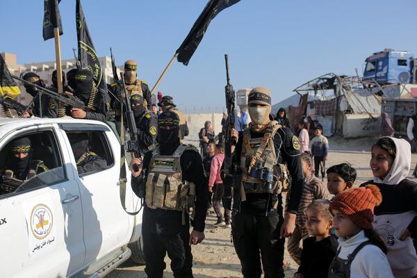 A crowd greets Islamic Jihad and Hamas fighters as they arrive for the hand-over of Israeli and Thai hostages to the Red Cross in the south Gaza Strip town of Khan Younis, Thursday Jan. 30, 2025. (AP Photo/Jehad Alshrafi)