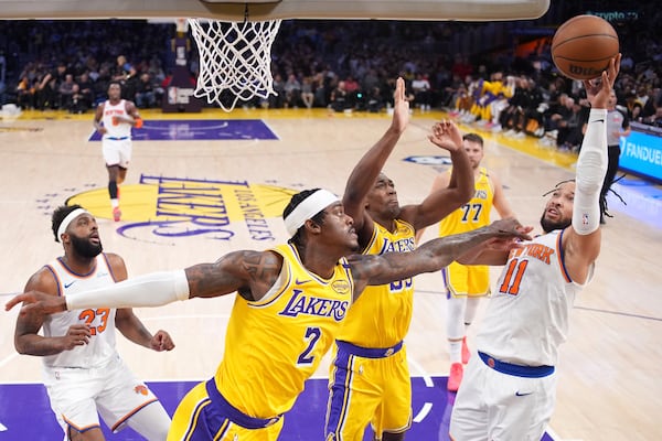 New York Knicks guard Jalen Brunson (11) shoots as Los Angeles Lakers forward Jarred Vanderbilt (2) and center Trey Jemison III (55) defend during the first half of an NBA basketball game Thursday, March 6, 2025, in Los Angeles. (AP Photo/Mark J. Terrill)