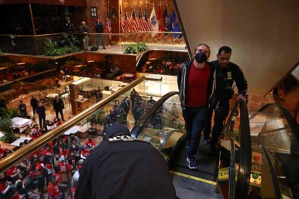 A demonstrator from the group, Jewish Voice for Peace, who protested inside Trump Tower in support of Columbia graduate student Mahmoud Khalil is escorted out by New York Police officers after being arrested, Thursday, March 13, 2025, in New York. (AP Photo/Yuki Iwamura)