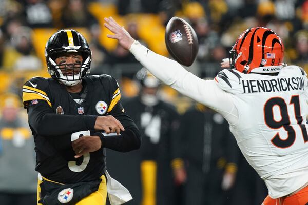 Pittsburgh Steelers quarterback Russell Wilson (3) throws a pass as Cincinnati Bengals defensive end Trey Hendrickson (91) moves in during the first half of an NFL football game in Pittsburgh, Saturday, Jan. 4, 2025. (AP Photo/Matt Freed)