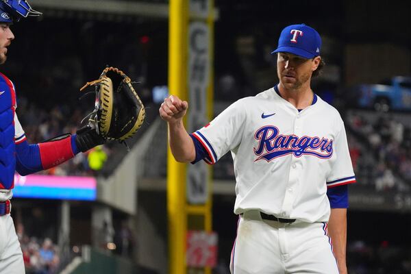 Texas Rangers starting pitcher Jacob deGrom, right, reaches out to teammate catcher Jonah Heim after the final out ending the seventh inning of a baseball game against the Houston Astros, Thursday, May 15, 2025, in Arlington, Texas. (AP Photo/LM Otero)