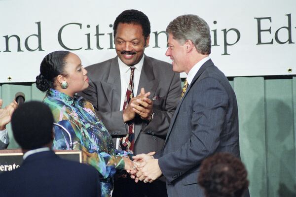 FILE - Democratic presidential candidate Bill Clinton, right, greets Santita Jackson, left, daughter of Jesse Jackson, center, at a "Rebuild America" conference in Washington, June 13, 1992. (AP Photo/Greg Gibson, File)