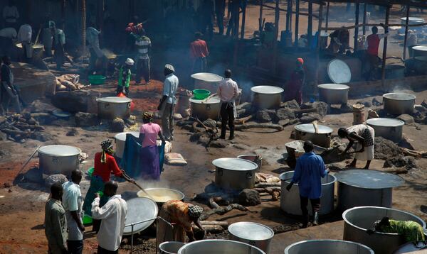 FILE -Refugees prepare food including maize porridge donated by USAID and known locally as posho, during the visit of U.N., Aug. 29, 2016. (AP Photo/Stephen Wandera, File)