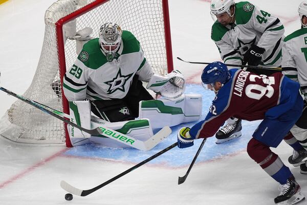 Colorado Avalanche left wing Gabriel Landeskog, bottom right, shoots the puck as Dallas Stars defenseman Cody Ceci (44) and goaltender Jake Oettinger, left, cover in the first period of Game 6 of an NHL hockey first-round playoff series Thursday, May 1, 2025, in Denver. (AP Photo/David Zalubowski)