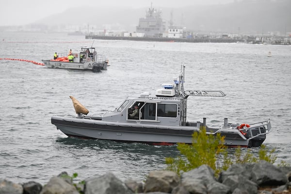 U.S. Navy boats work along the shore near Shelter Island after a U.S. Navy plane crashed into the San Diego Bay, Wednesday, Feb. 12, 2025, in San Diego. (AP Photo/Denis Poroy)